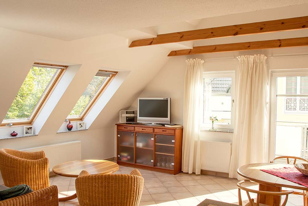 Heller Wohnbereich mit Dachschrägen und TV – Ferienwohnung 9 in Zinnowitz